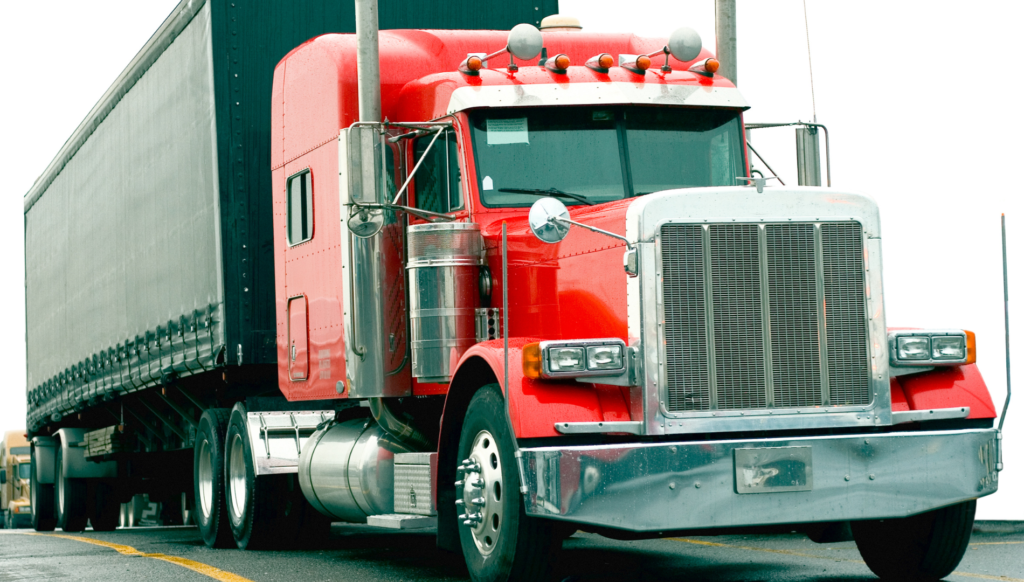 Red semi truck with trailer parked on a roadway.