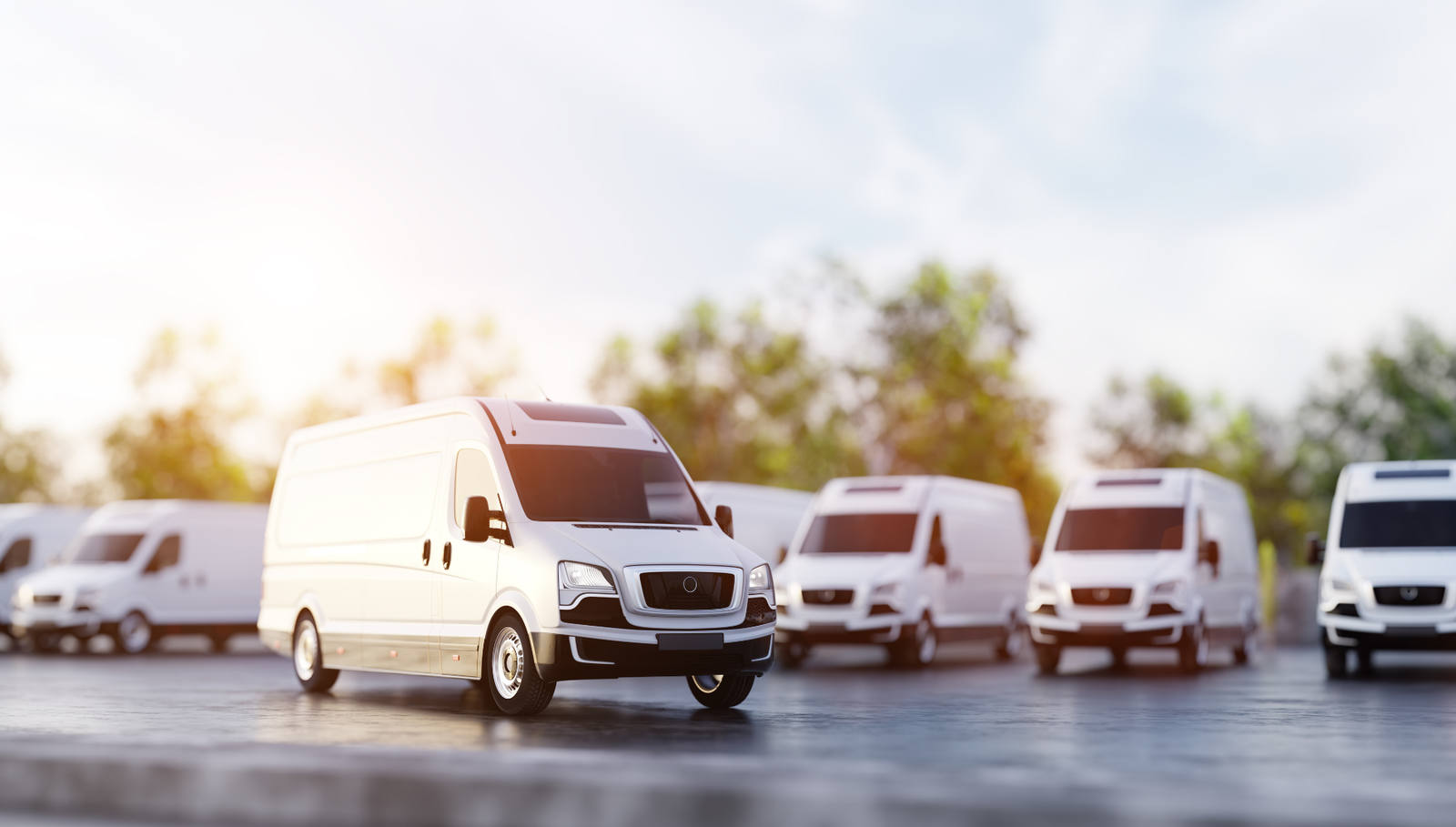 White cargo van parked with delivery fleet in background.