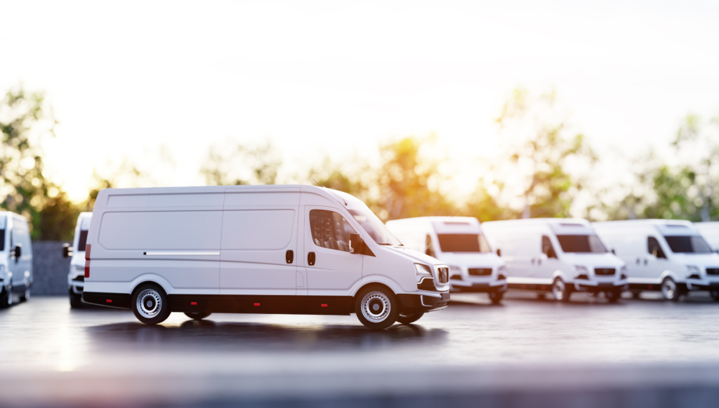 White cargo van parked with fleet vehicles at sunset.