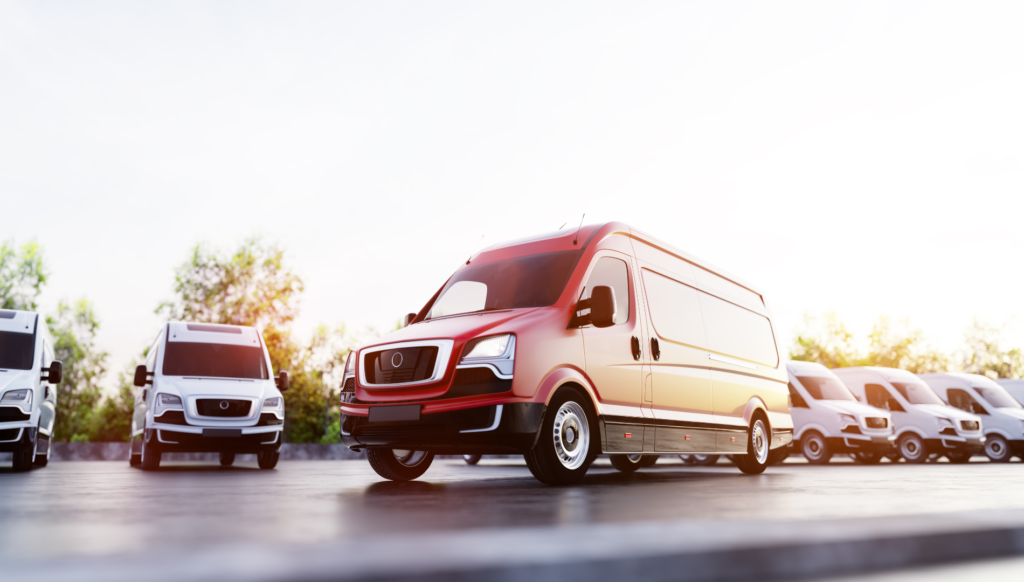 Red cargo van parked with delivery fleet in background.