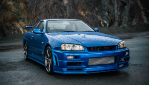 Blue sports coupe parked on a wet mountain road.