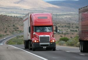Red semi truck driving on highway
