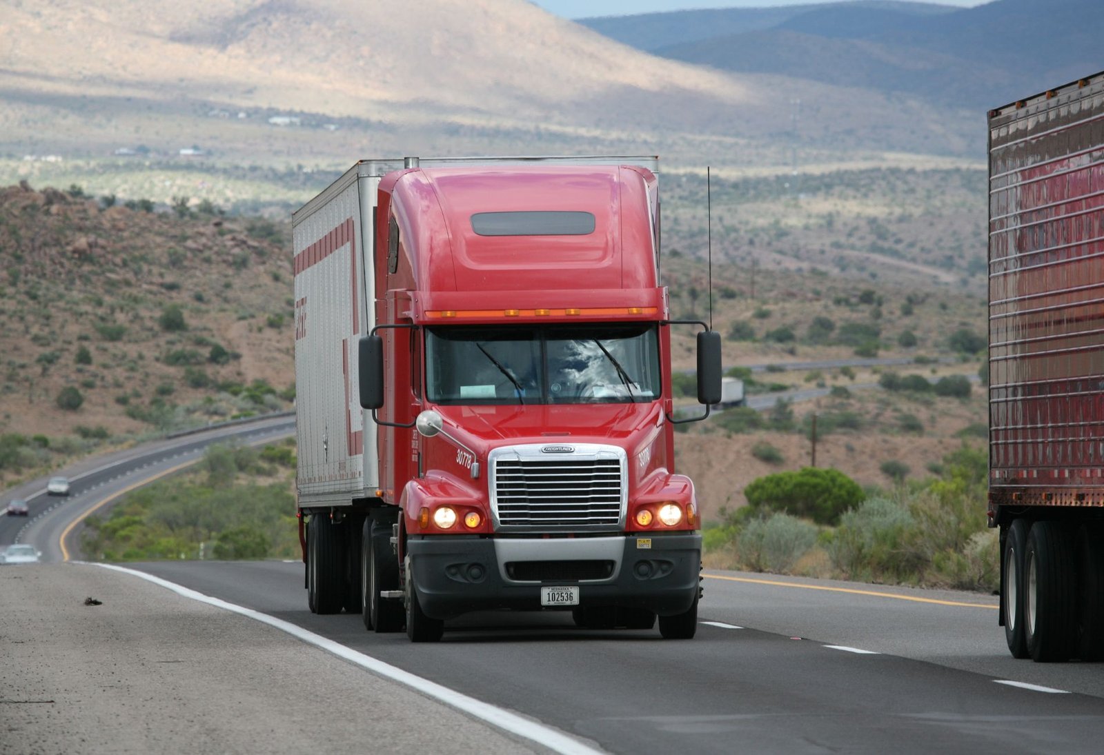 Red semi truck driving on highway
