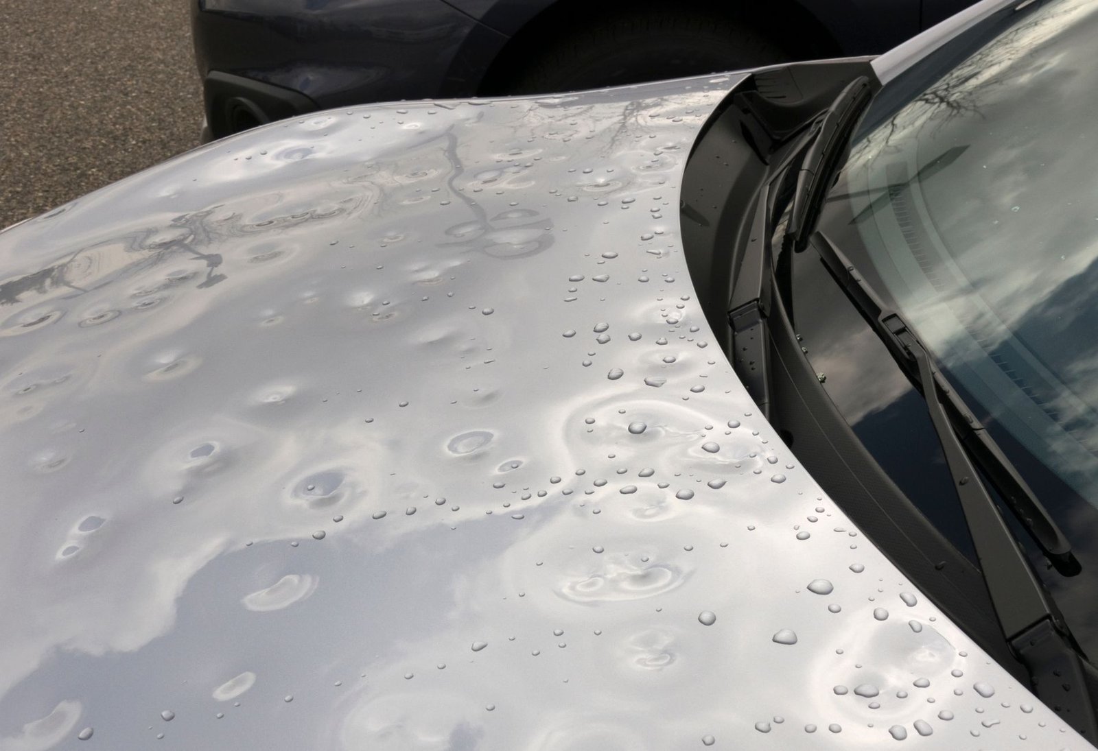 Silver car hood with hail dents